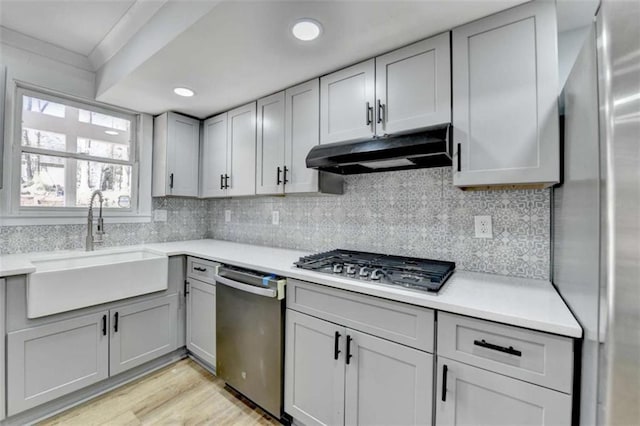 kitchen with gray cabinets, appliances with stainless steel finishes, sink, and decorative backsplash