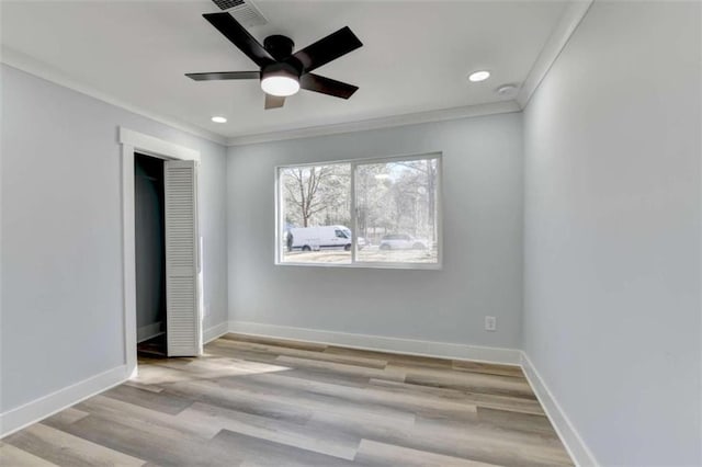 unfurnished bedroom featuring crown molding, ceiling fan, light wood-type flooring, and a closet