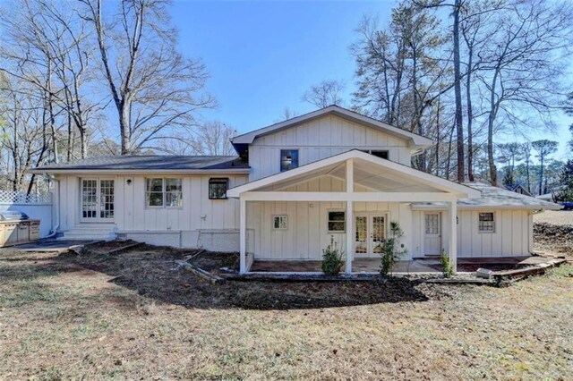 back of property with a yard and french doors