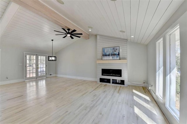 unfurnished living room with french doors, lofted ceiling with beams, light hardwood / wood-style flooring, wooden ceiling, and a large fireplace