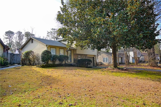 tri-level home with a garage and a front yard