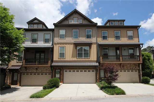 townhome / multi-family property with an attached garage, driveway, board and batten siding, and a balcony
