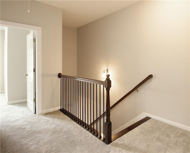 stairway featuring carpet floors and baseboards