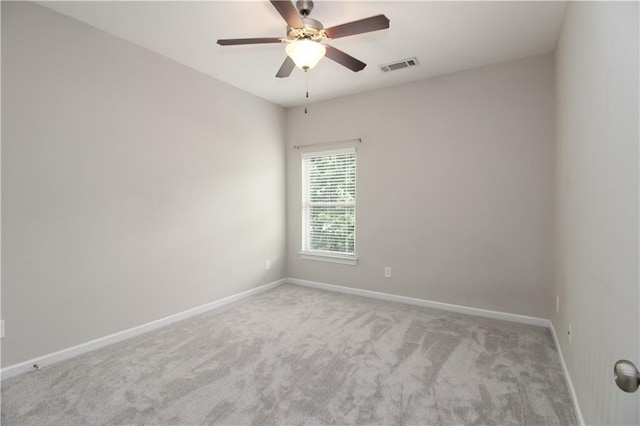 carpeted empty room featuring baseboards and ceiling fan