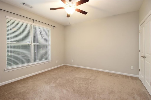 empty room with carpet floors, baseboards, and a ceiling fan