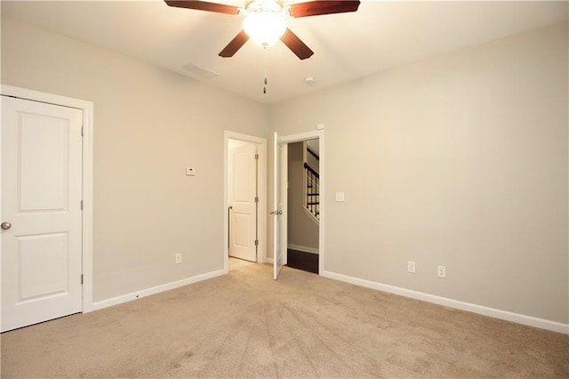 unfurnished bedroom with light colored carpet, baseboards, and ceiling fan