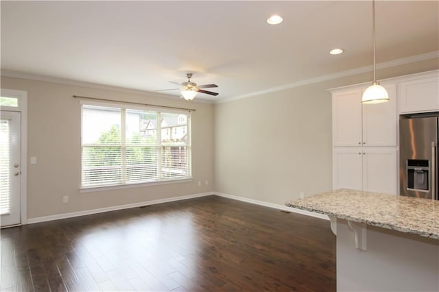 unfurnished living room with ceiling fan, healthy amount of natural light, ornamental molding, baseboards, and recessed lighting