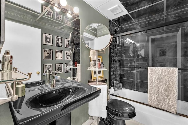 full bath with enclosed tub / shower combo, toilet, and a sink