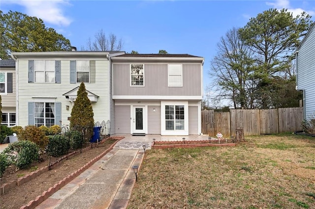 view of front facade with a patio, a front yard, and fence