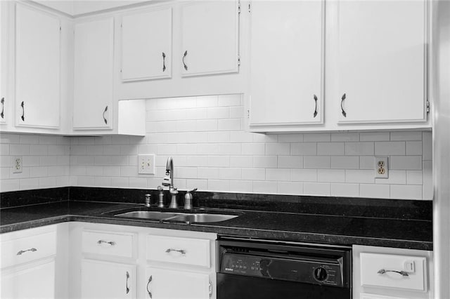 kitchen featuring dark countertops, a sink, and white cabinets