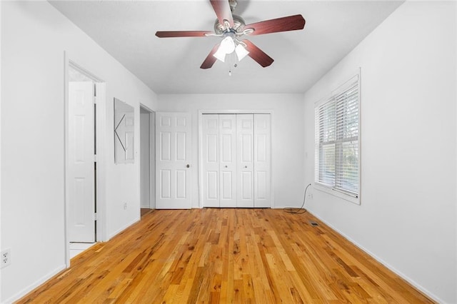 unfurnished bedroom featuring ceiling fan, light wood finished floors, and a closet