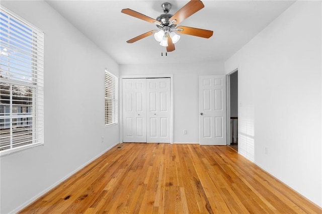 unfurnished bedroom with light wood-type flooring, a ceiling fan, and a closet