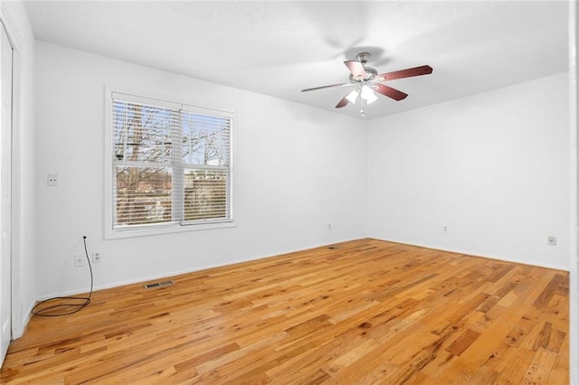 spare room with visible vents, ceiling fan, and light wood-style flooring