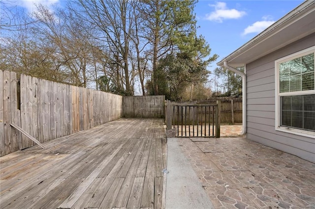 wooden terrace featuring a fenced backyard and a patio