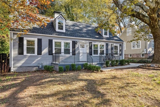 cape cod house with a front lawn