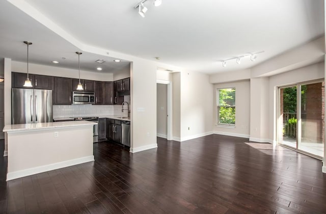 kitchen with dark brown cabinetry, dark hardwood / wood-style floors, sink, hanging light fixtures, and appliances with stainless steel finishes