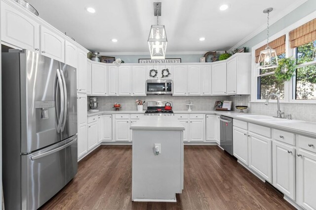 kitchen featuring dark wood-type flooring, appliances with stainless steel finishes, white cabinetry, a kitchen island, and decorative light fixtures