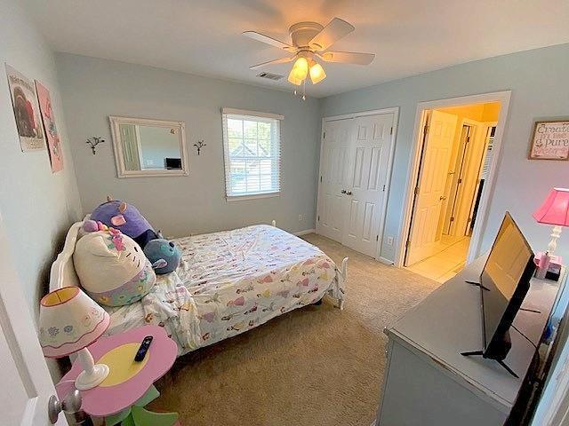 carpeted bedroom with a closet and ceiling fan