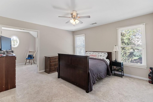 carpeted bedroom featuring multiple windows and ceiling fan