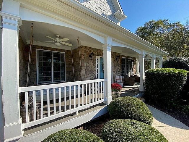 entrance to property with ceiling fan and a porch