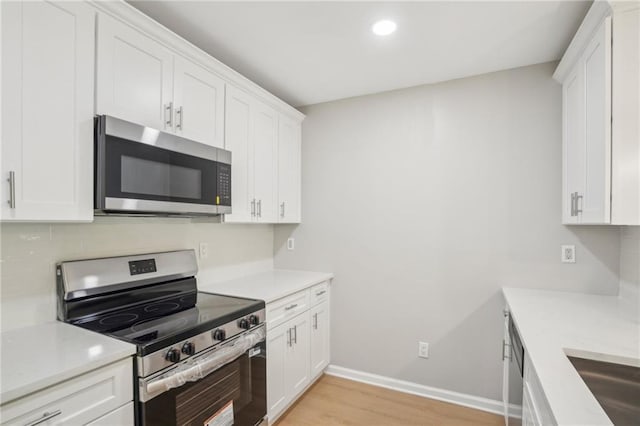 789 Third St, Stone Mountain, GA 30083 - kitchen with appliances with stainless steel finishes, light wood-style floors, white cabinets, light countertops, and baseboards