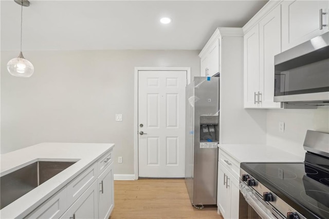789 Third St, Stone Mountain, GA 30083 - kitchen with appliances with stainless steel finishes, light wood-type flooring, white cabinets, light countertops, and pendant lighting