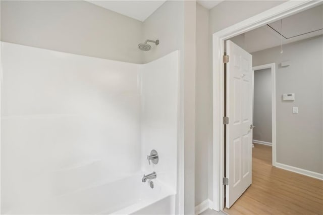 789 Third St, Stone Mountain, GA 30083 - bathroom featuring baseboards, washtub / shower combination, and wood finished floors