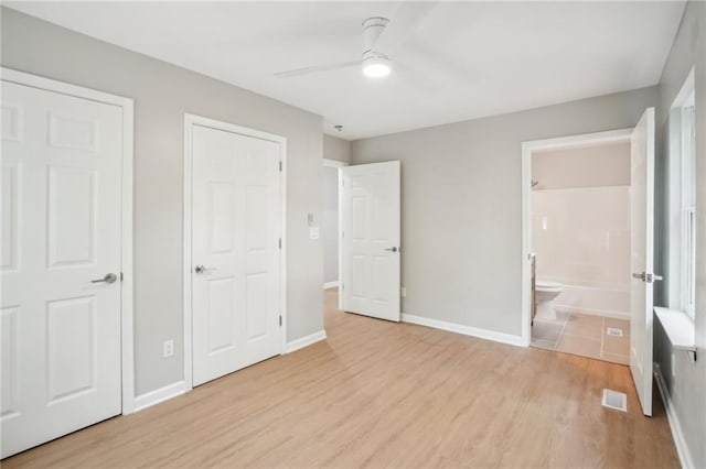 789 Third St, Stone Mountain, GA 30083 - unfurnished bedroom featuring light wood-style flooring, ensuite bath, baseboards, and ceiling fan