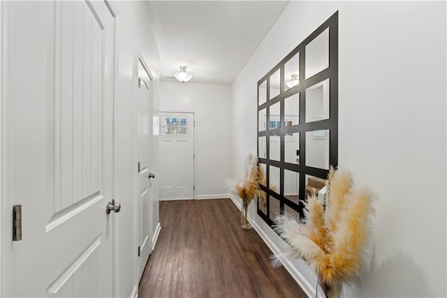hall featuring baseboards and dark wood finished floors