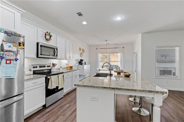 kitchen with a center island with sink, a sink, dark wood-style floors, visible vents, and appliances with stainless steel finishes