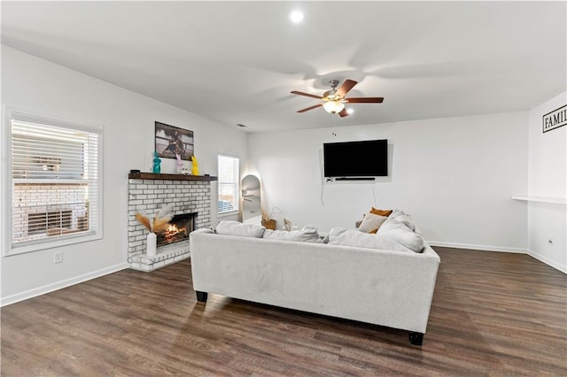 living area with baseboards, a fireplace, wood finished floors, and ceiling fan
