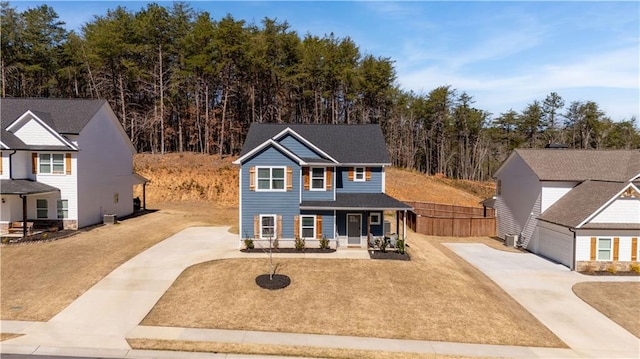traditional home with driveway, covered porch, and fence