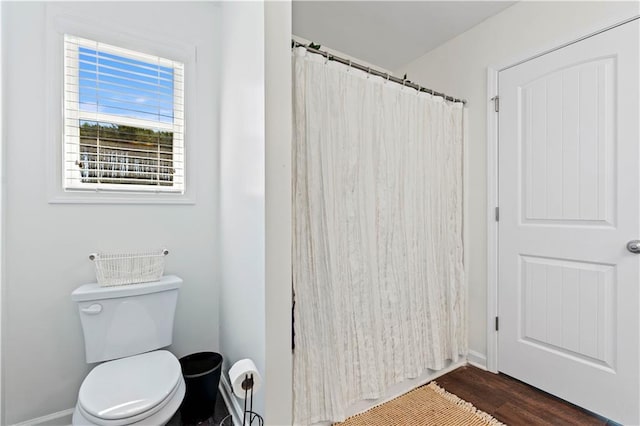 full bath with toilet, curtained shower, and wood finished floors