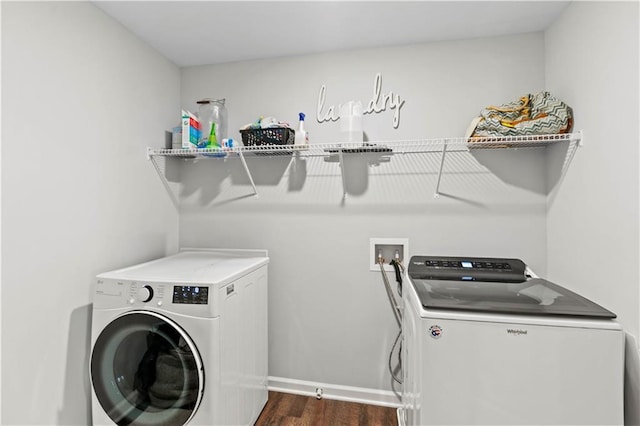 washroom with baseboards, laundry area, washer and dryer, and dark wood finished floors