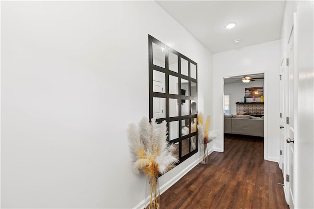 corridor featuring baseboards and dark wood finished floors