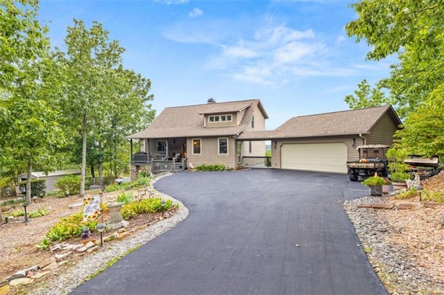 view of front of property with covered porch, aphalt driveway, and a garage