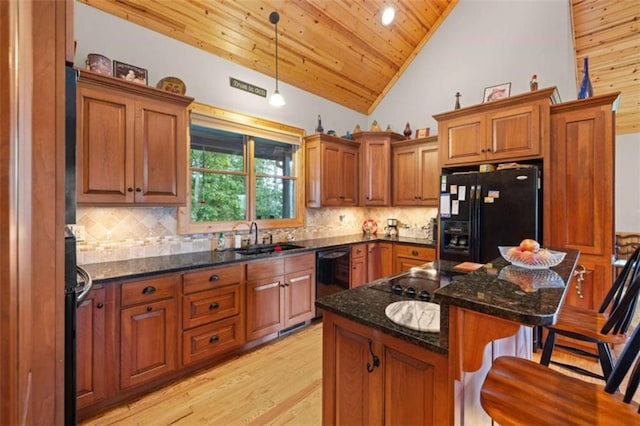 kitchen with black appliances, wooden ceiling, brown cabinetry, and a sink