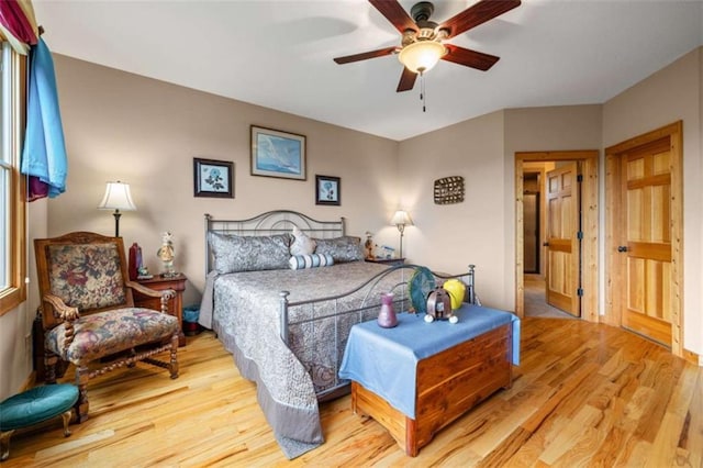 bedroom with a ceiling fan and light wood-style flooring