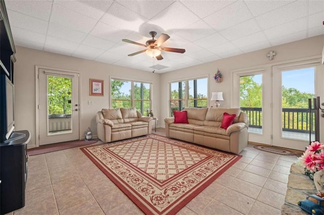 living room with light tile patterned floors, ceiling fan, and a paneled ceiling