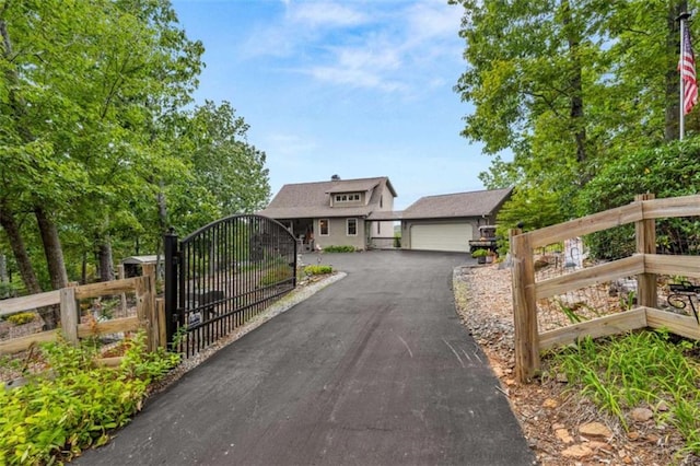 chalet / cabin featuring a gate, fence, and a garage