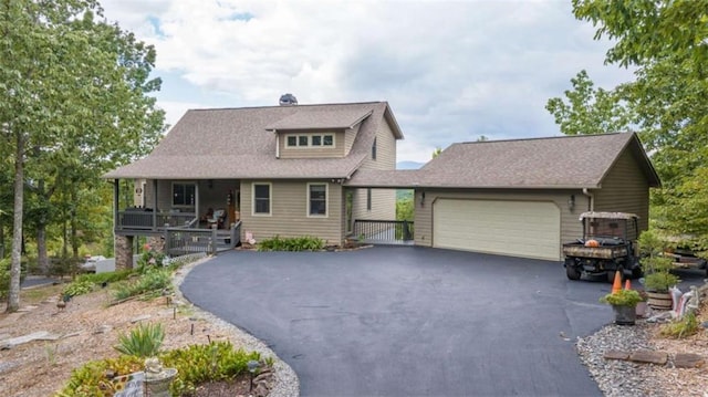 view of front of home with covered porch, aphalt driveway, and an attached garage