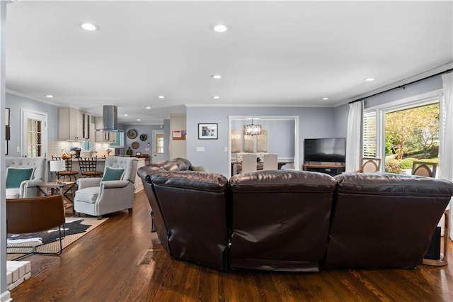 living room with ornamental molding, an inviting chandelier, and dark hardwood / wood-style floors