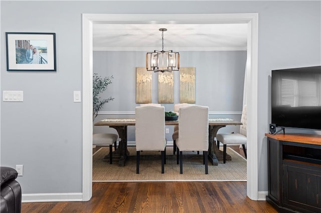 dining area featuring a chandelier, dark hardwood / wood-style floors, and ornamental molding