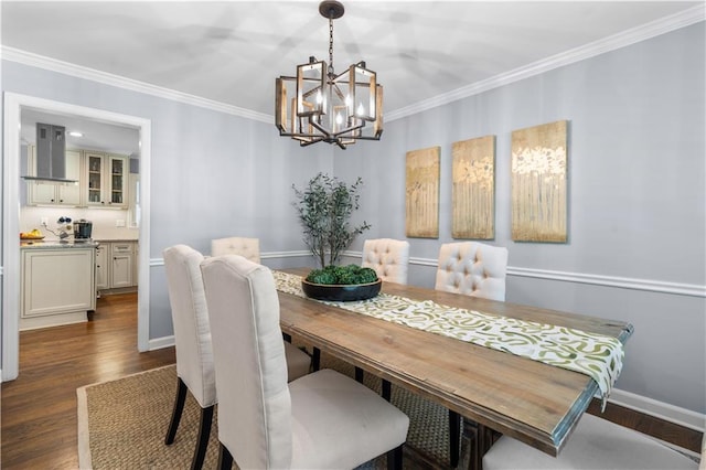 dining area with dark wood-type flooring, crown molding, and an inviting chandelier