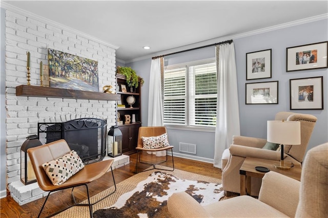 living room featuring hardwood / wood-style floors, a fireplace, and crown molding