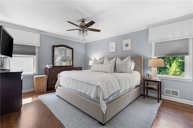 bedroom with crown molding, dark wood-type flooring, multiple windows, and ceiling fan