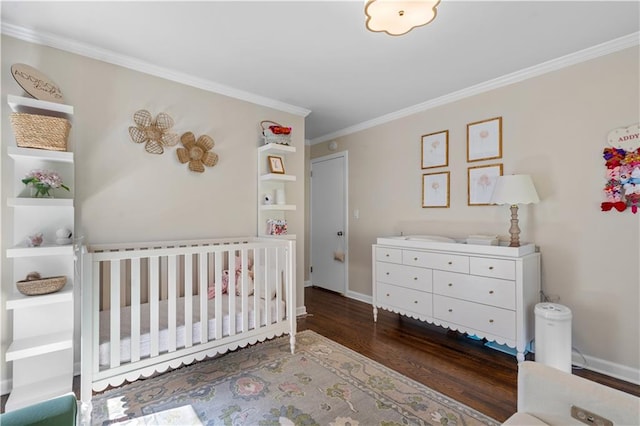 bedroom featuring a crib, dark wood-type flooring, and ornamental molding