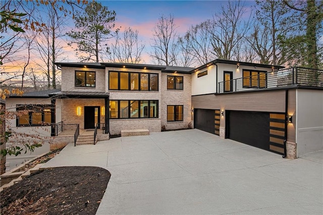 view of front facade with concrete driveway, a balcony, and an attached garage