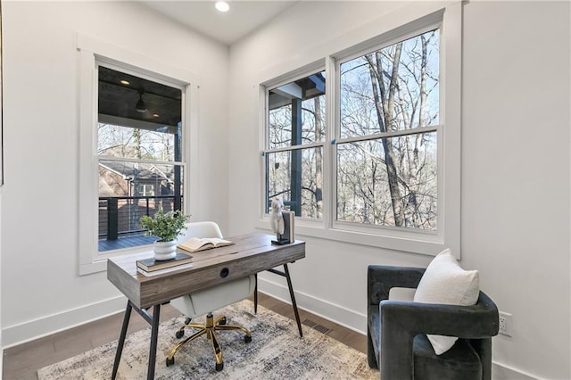 office with a healthy amount of sunlight, baseboards, and wood finished floors