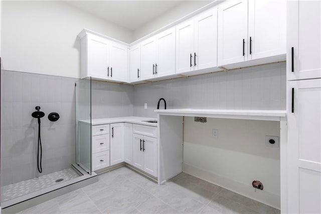 washroom featuring a sink, cabinet space, and electric dryer hookup